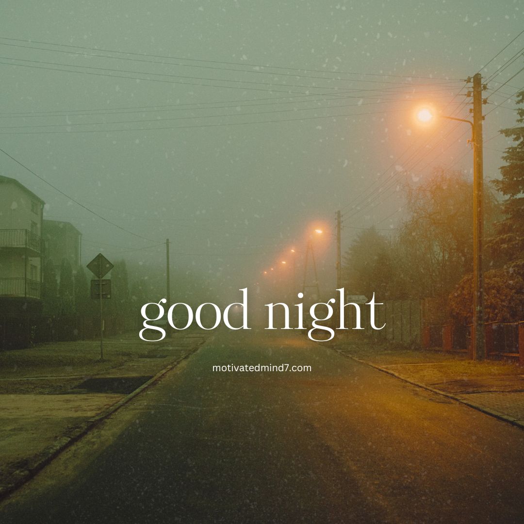 Foggy night scene on a street illuminated by warm streetlights. The street is lined with houses and trees, with power lines visible above. The misty atmosphere and soft lighting create a serene, mysterious ambiance.