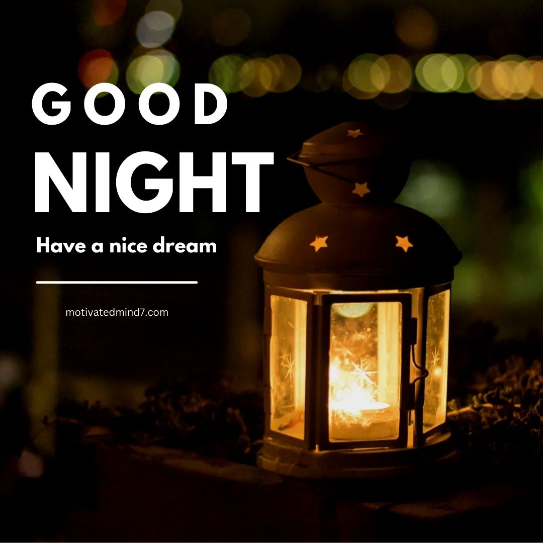 Good Night Image featuring a softly lit lantern with star-shaped cutouts on its top. The lantern is placed on a surface with a blurred background of city lights at night. The text on the image reads 'GOOD NIGHT' and 'Have a nice dream'.