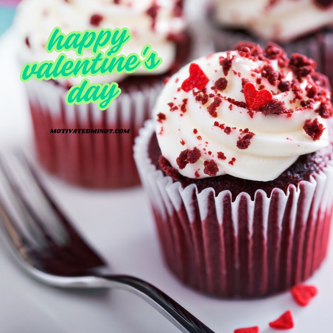 Cupcake having white cream with red hearts on it.